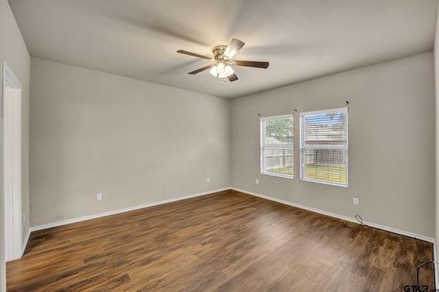 spare room featuring dark wood-type flooring and ceiling fan