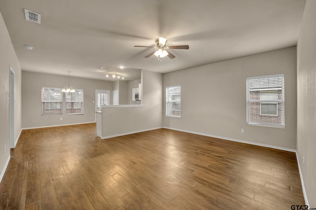 interior space with ceiling fan with notable chandelier and hardwood / wood-style flooring