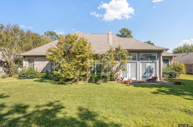 rear view of house featuring a patio and a yard