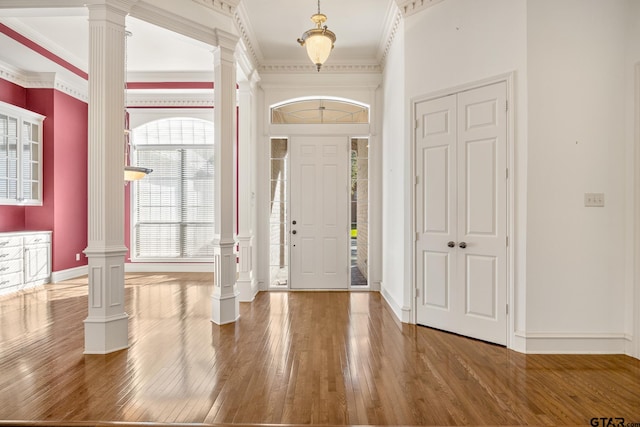 foyer with ornamental molding, hardwood / wood-style floors, and decorative columns