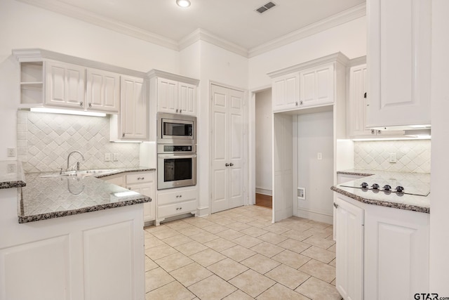 kitchen featuring white cabinetry, sink, appliances with stainless steel finishes, dark stone countertops, and crown molding