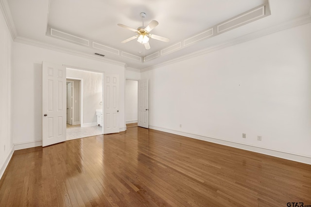 unfurnished room featuring crown molding, hardwood / wood-style floors, ceiling fan, and a raised ceiling