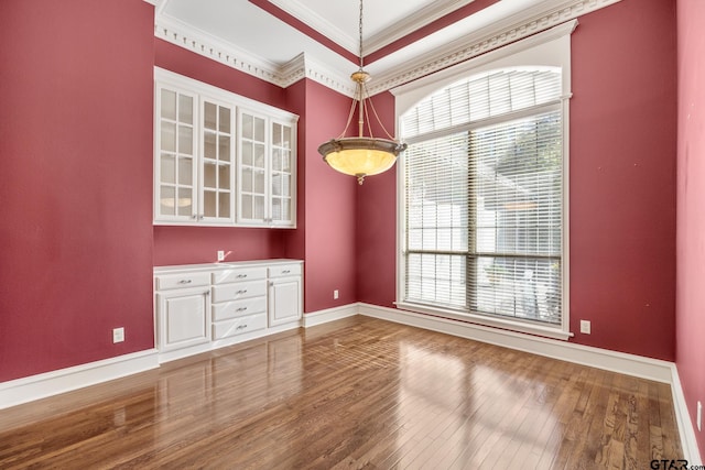 unfurnished dining area with hardwood / wood-style floors and crown molding