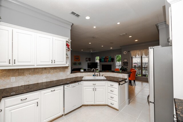 kitchen featuring sink, white cabinetry, dishwasher, stainless steel fridge, and kitchen peninsula