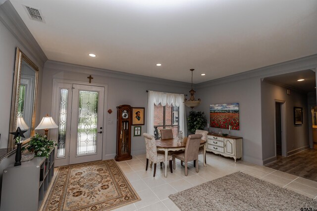 dining area with ornamental molding and light tile patterned flooring