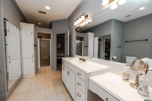 bathroom featuring tile patterned floors, ornamental molding, toilet, vanity, and walk in shower