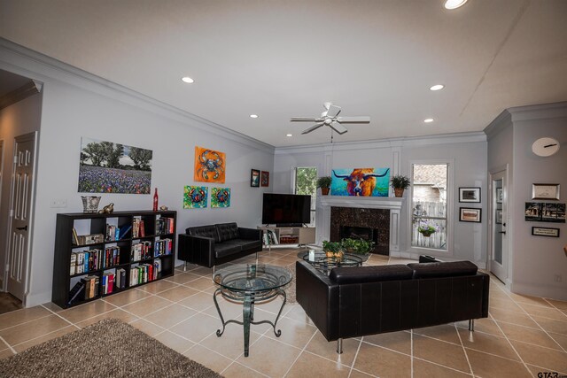 tiled living room with ceiling fan, ornamental molding, and a fireplace