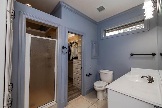 bathroom with ornamental molding, toilet, tile patterned floors, and walk in shower