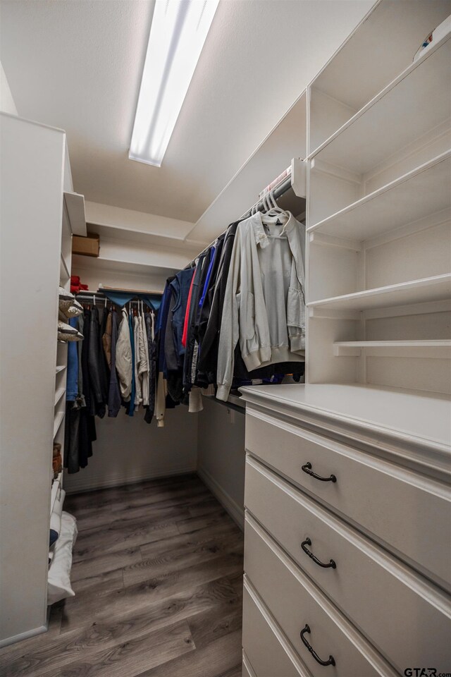 spacious closet with dark hardwood / wood-style flooring