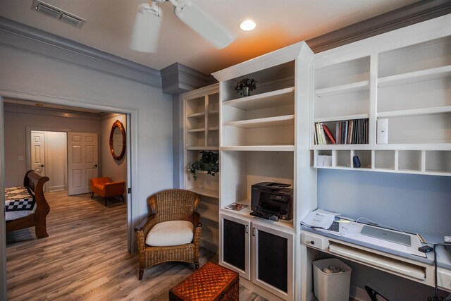 living area featuring ornamental molding, ceiling fan, and wood-type flooring