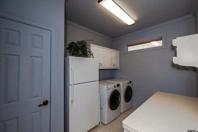 laundry area featuring light tile patterned flooring, crown molding, washer and clothes dryer, and cabinets