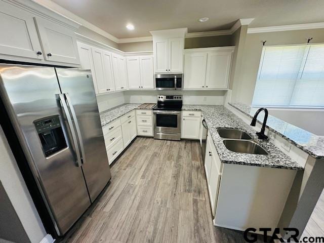 kitchen with light hardwood / wood-style flooring, white cabinetry, sink, and stainless steel appliances