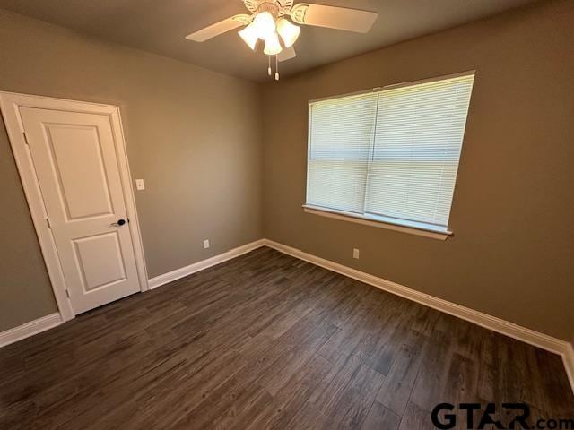 empty room featuring ceiling fan and dark hardwood / wood-style floors