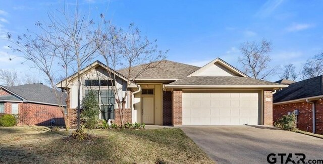 view of front of home with a front lawn and a garage