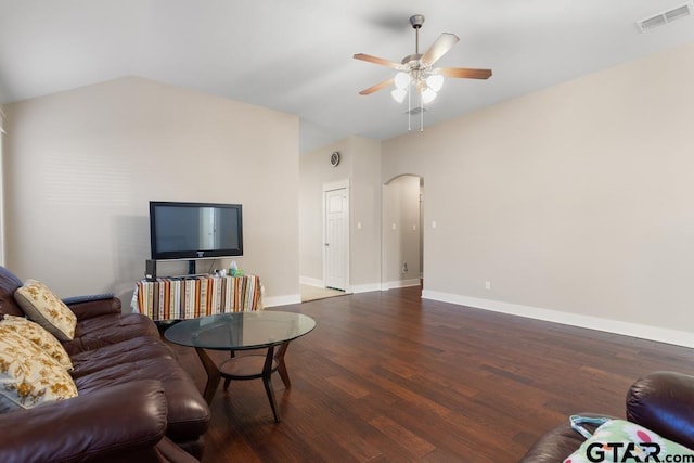 living room featuring dark hardwood / wood-style floors, ceiling fan, and vaulted ceiling