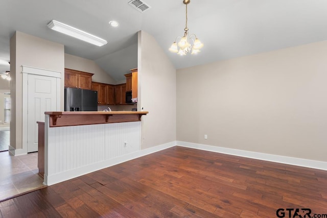 6023 Grace Ave, Tyler, TX 75707 - living area featuring wood finished floors, vaulted ceiling, ceiling fan, baseboards, and a chandelier