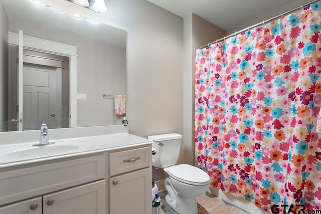 bathroom with tile patterned floors, vanity, toilet, and walk in shower