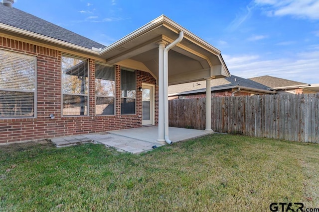 rear view of house featuring a lawn and a patio