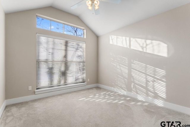 carpeted spare room featuring ceiling fan, a healthy amount of sunlight, and lofted ceiling