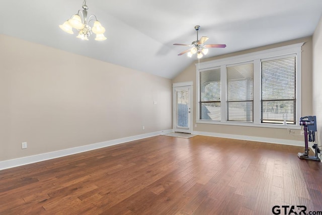 empty room featuring ceiling fan with notable chandelier, dark hardwood / wood-style floors, and lofted ceiling