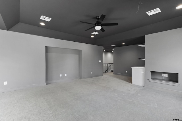 unfurnished living room featuring light colored carpet and ceiling fan