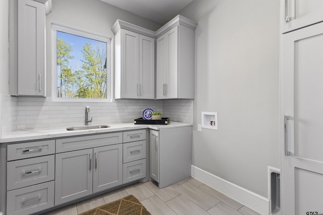 laundry room featuring hookup for a washing machine, sink, and cabinets