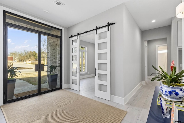 doorway featuring a barn door, light tile patterned floors, and french doors