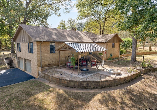 rear view of property featuring a garage and a patio area