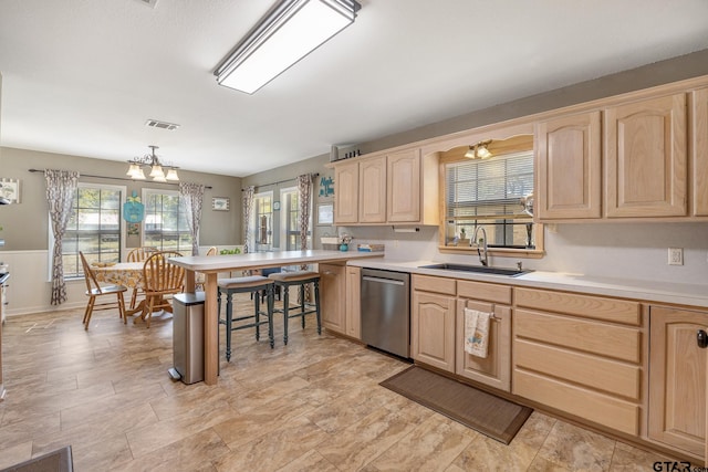 kitchen featuring sink, light brown cabinets, decorative light fixtures, a chandelier, and dishwasher