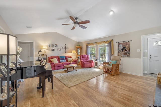 living room with light wood-type flooring, ceiling fan, and vaulted ceiling