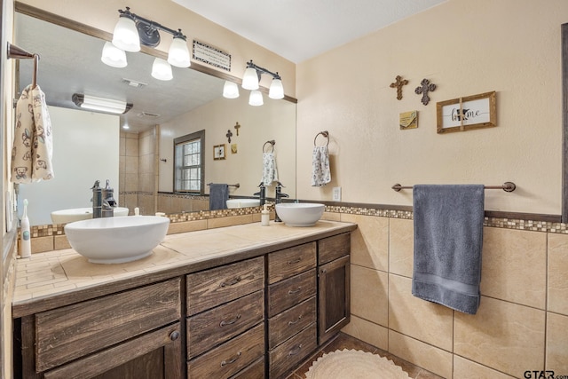 bathroom with vanity and tile walls