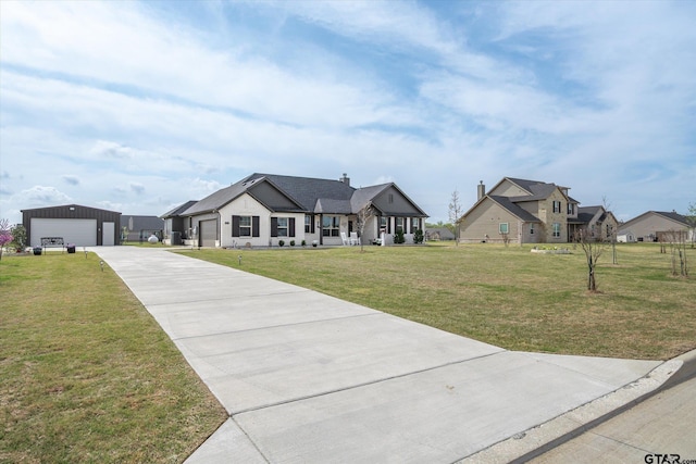 modern farmhouse with a front lawn, driveway, an outbuilding, and a detached garage
