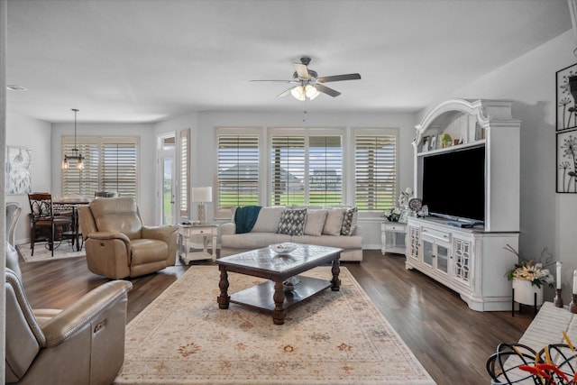 living area featuring ceiling fan and dark wood-type flooring