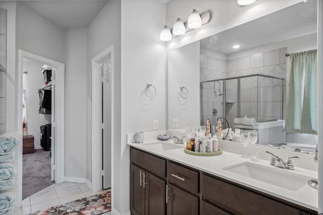 bathroom featuring tile patterned floors, a sink, double vanity, and a shower stall