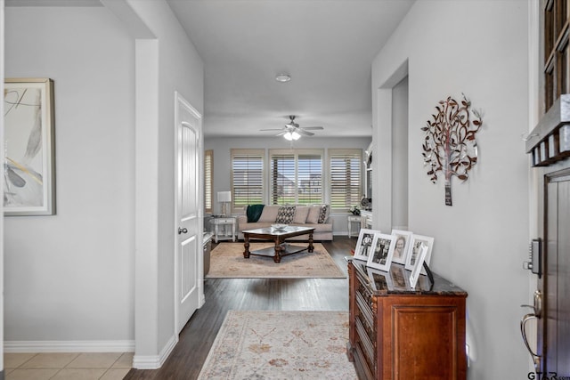 foyer entrance with baseboards, ceiling fan, and dark wood finished floors