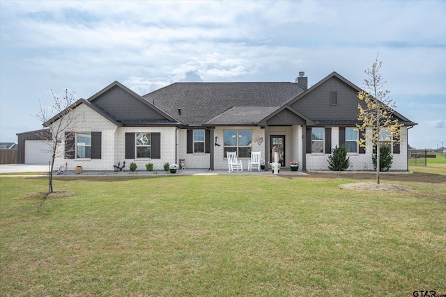 view of front facade with a front yard, concrete driveway, an attached garage, brick siding, and a shingled roof