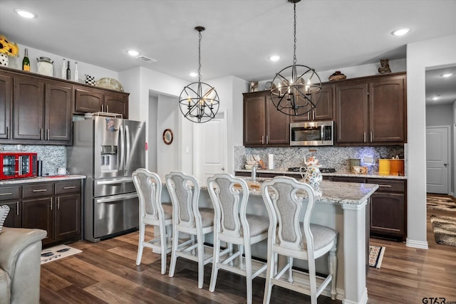 kitchen featuring an inviting chandelier, dark brown cabinets, appliances with stainless steel finishes, and visible vents