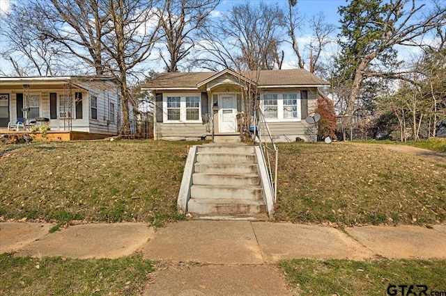 bungalow featuring covered porch and a front lawn