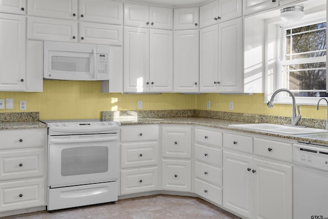 kitchen with sink, white appliances, and white cabinets