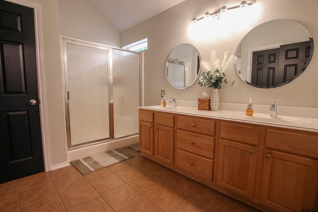 bathroom with tile patterned flooring, vaulted ceiling, a sink, and a shower stall