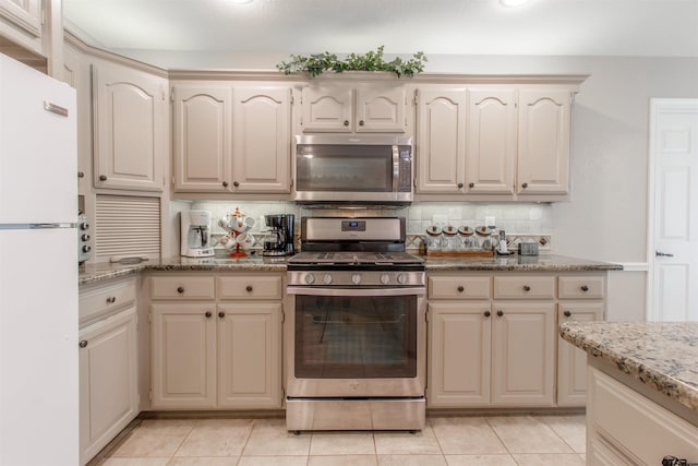 18400 Woodhollow Dr, Flint, TX 75762 - kitchen with stainless steel appliances, tasteful backsplash, cream cabinetry, and light stone counters