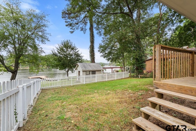 view of yard with a deck with water view