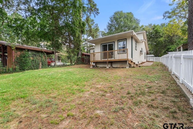 rear view of house with a yard and a deck