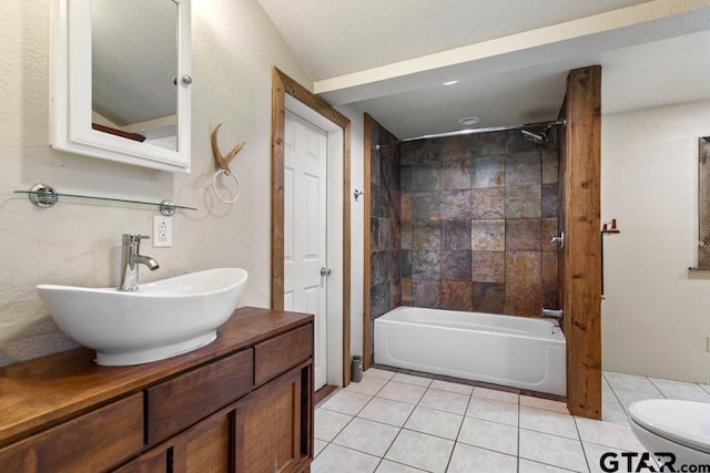 full bathroom with tile patterned flooring, tiled shower / bath, vanity, and toilet