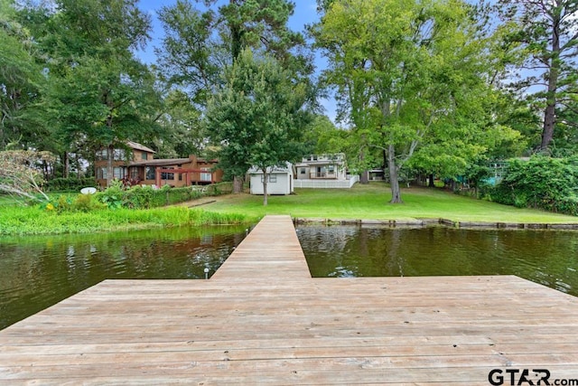 dock area with a water view and a lawn