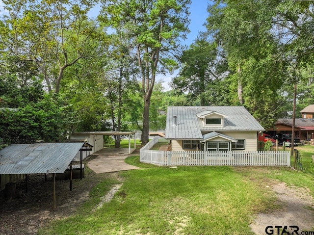 rear view of property with a lawn and a carport