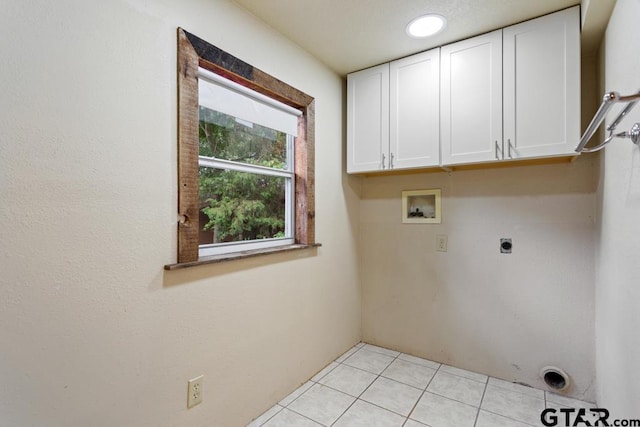 washroom featuring electric dryer hookup, light tile patterned floors, hookup for a washing machine, and cabinets