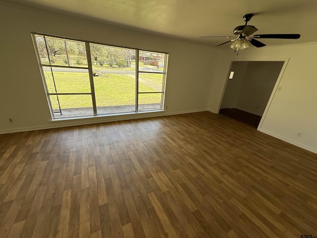 unfurnished living room featuring dark wood-style floors, baseboards, and ceiling fan