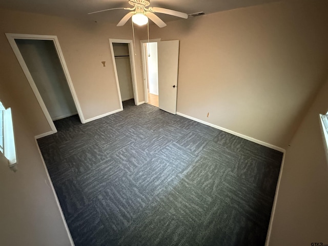 unfurnished bedroom featuring visible vents, ceiling fan, baseboards, and dark colored carpet