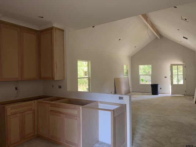 kitchen featuring high vaulted ceiling, light brown cabinetry, light carpet, and beam ceiling